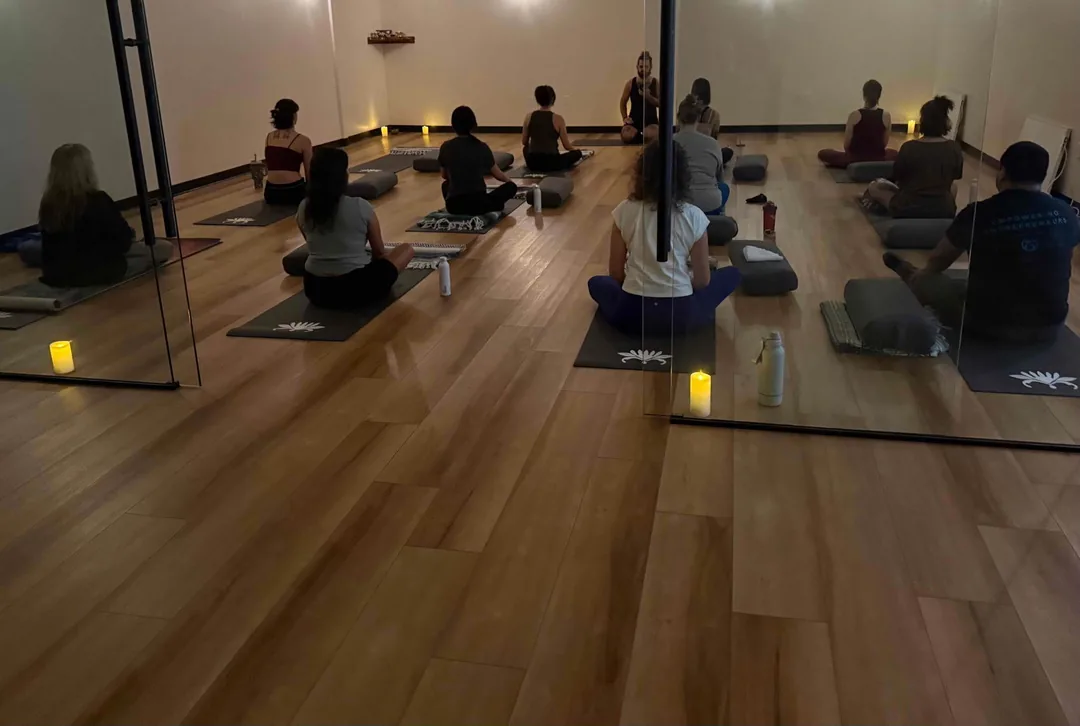 Liquid Breathwork graduate Devin guiding a candlelit Breathwork class in a studio